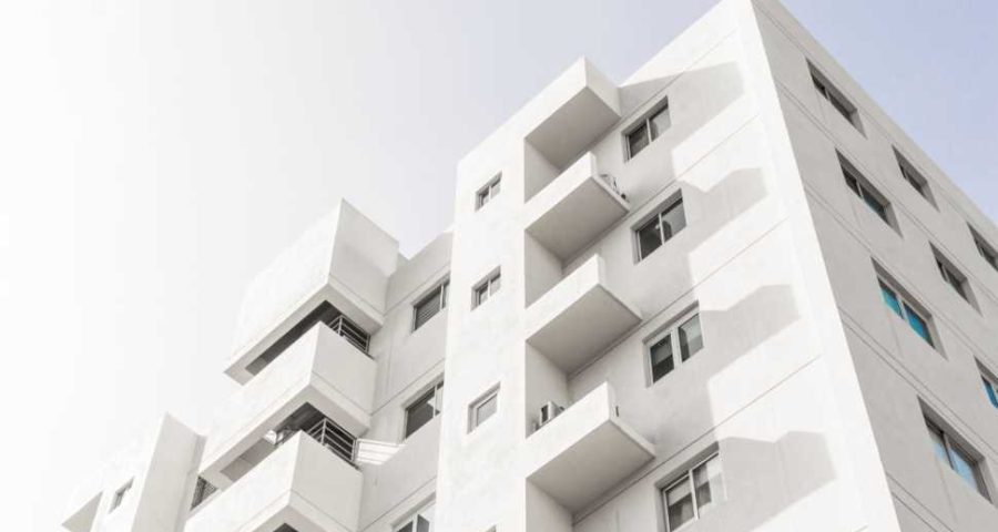 low-angle-shot-of-a-facade-of-a-white-modern-building-under-a-blue-clear-sky (1)