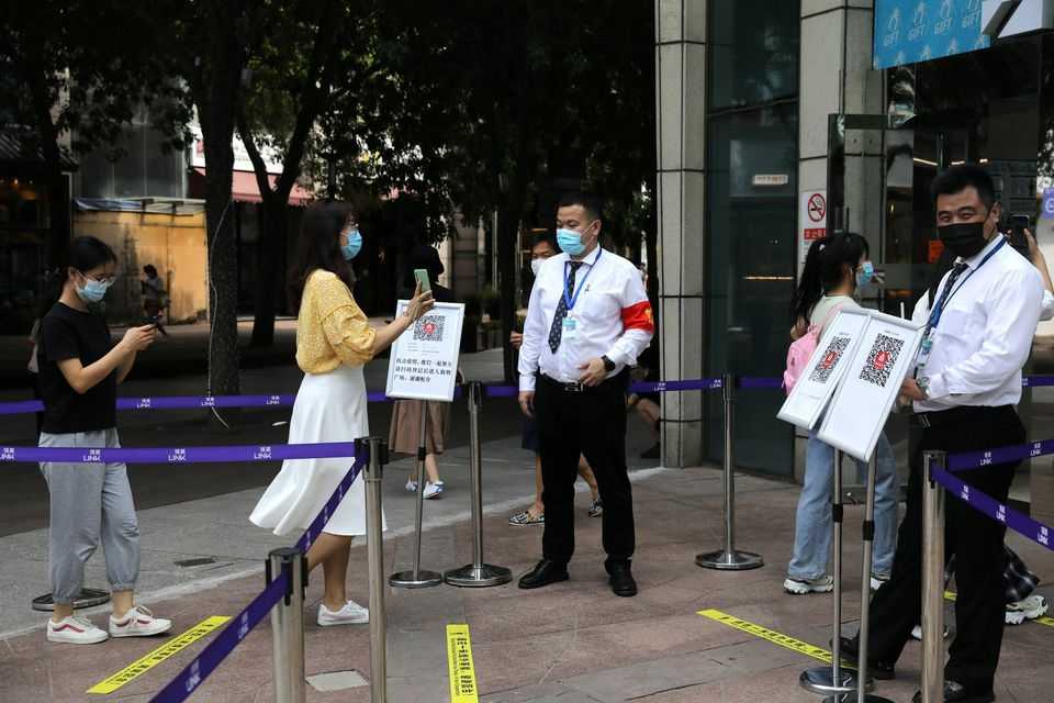 Uma mulher mostra seu estado de saúde em um telefone para um segurança, na entrada de um shopping center em Pequim, China, 23 de agosto de 2021. REUTERS/Tingshu Wang/Foto de arquivo